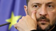 Volodymyr Zelenskyi kasvot lähikuvassa. Hän pyyhkäisee silmän alustaan peukalollaan.