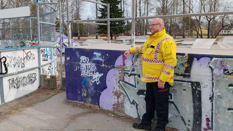 Paloviranomainen seisoo koulun pihaan rakennettujen liikuntakohteiden vieressä.