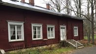 Punainen vanha rakennus. Rakennuksessa on valkoiset ikkunapuut. 