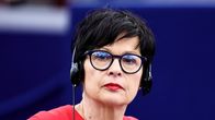 Marta Kos istuu kokouksessa kuulokkeet päässään.