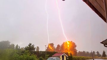 Salama iskee puuhun pihan reunalla, ja puu syttyy palamaan lähellä autoa ja pientä rakennusta.