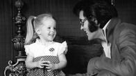 Elvis pulisongeissaan tyttärensä kanssa. Tytöllä pilkullinen hame.