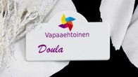 Vapaaehtoinen doula -kyltti henkilön rinnassa.