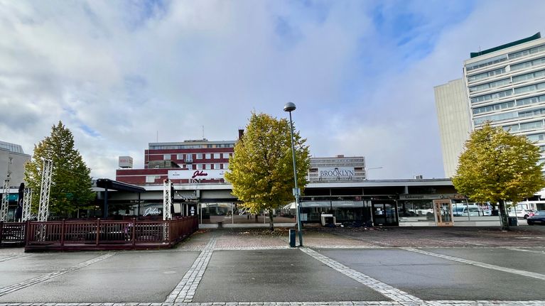 Tyhjä toriaukio, jonka taustalla näkyy tyhjä ravintolan terassi.