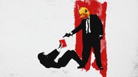 Ett bildkollage med inspiration från en känd scen ur filmen Reservoir dogs, där en person ligger på marken med penna och papper i handen medan en person som föreställer svenskfinlands "ankdamm" står ovanför med en pistol riktat mot den liggande personen.