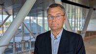 Vanhempi mieshenkilö seisoo sairaalarakennuksen käytävällä.