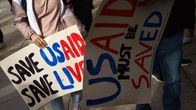 Kylttejä, joissa lukee "Save USAID, save lives".