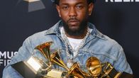 Kendrick Lamar poseeraa viiden Grammy-patsaan kanssa punaisella matolla.