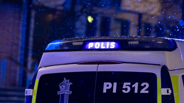 Poliisiauton vilkkuva valokyltti pimeässä yössä.