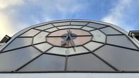 Karkkilan Yhteiskoulun ulkoseinässä on iso, värikäs kello.