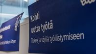 Sininen kyltti, jossa lukee "Kohti uutta työtä" ja "Tukea ja väyliä työllistymiseen".