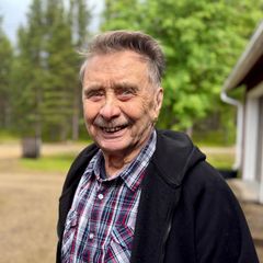 Vanhempi mies hymyilee leveästi kotipihallaan. Kauko Feodoroff. 