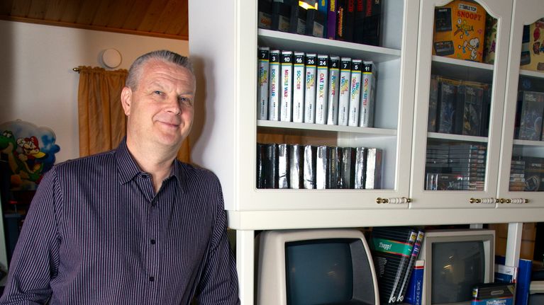 Ata Tommiska nojailee keittiön tasoon, joka on täynnä retrotietokoneita.