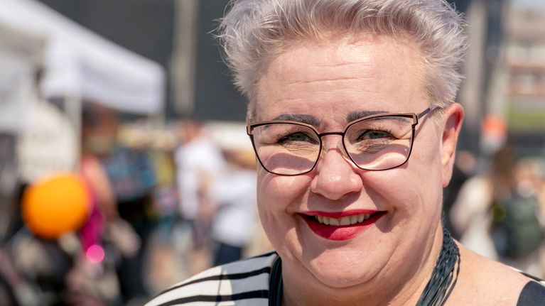 Leende kvinna tittar i kameran. 