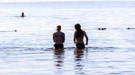 Uimarit kävelee Pyhäjärveen Pyynikin uimarannalla.