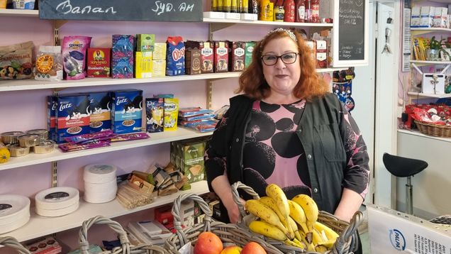 En kvinna står vid frukt i en bybutik i Gäddrag i Borgå.