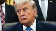 Donald Trump istuu katsoen sivulleen kuuntelevan näköisenä.