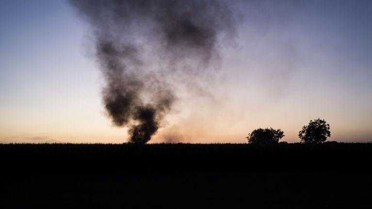 Ilta-auringossa näkyy tumma savupatsas.