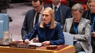Woman with blonde hair sitting at a desk and speaking at a UN Security Council meeting with a microphone in front of her.