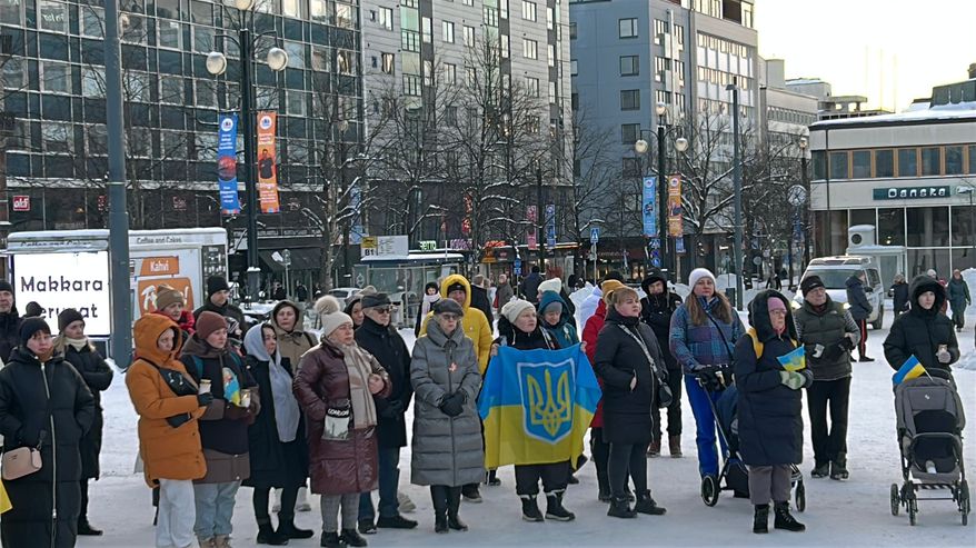 Ihmisä kokoontunut talviselle torille. Muutamilla käsissään Ukrainan lippu.
