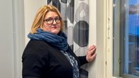 Regina Saari katsoo kameraan. Taustalla toimistotiloja.