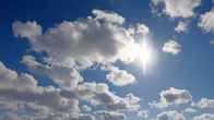 Aurinko paistaa kirkkaasti pilvien välistä.