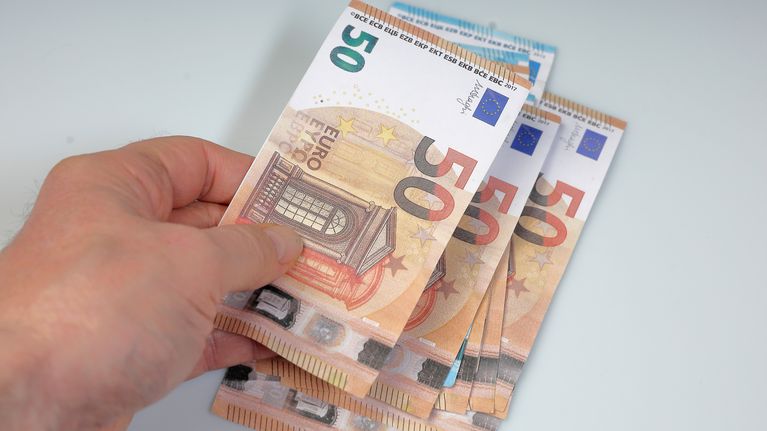 50 ja 20 euron seteleitä jonkun kädessä.