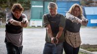 Tre poliser med skyddsvästar på har framdragna handeldvapen.