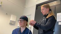 Hoitaja kytkee toisen hoitajan päässä olevaa masennuksen hoitoon tarkoitettua laitetta päälle.