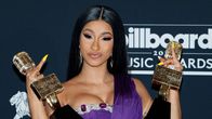 Cardi B pitelee palkintopystejä ja näyttää keskisormiaan.