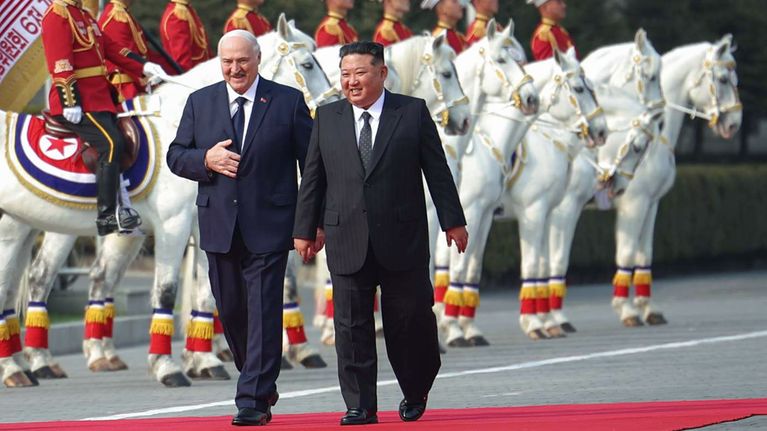 Pohjois-Korean johtaja Kim Jong-un ja Valko-Venäjän presidentti Aljaksandr Lukashenka kävelevät punaista mattoa pitkin.