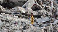 Lapsi seisoo romahdettujen betonirakennusten raunioissa Gazassa 1. heinäkuuta 2026.