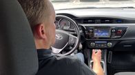 Kuljettaja ratin takana henkilöautossa. 