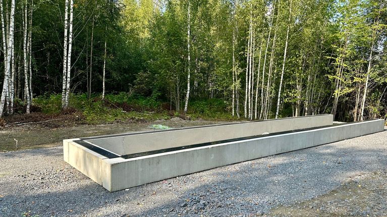 Sähköakkuvaraston betoninen kivijalka metsän keskellä.