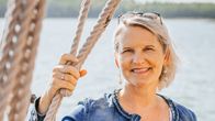 Sonja Enestam står och håller i rep på en båt och ser mot kameran.