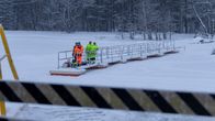 Kuutsalon ranta. Saaren asukkaita odottamassa yhteysalusta ponttonilaiturilla.
