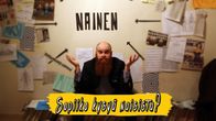 Parrakas mies levittelee käsiään. Seinällä sana "nainen" ja erilaisia lehtileikkeitä ja kaavioita.