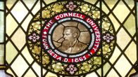 Ett emblem på en byggnad som föreställer en man med texten "Cornell University".