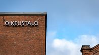 Oikeustalo -tekstikyltti punatiilisen rakennuksen seinässä.