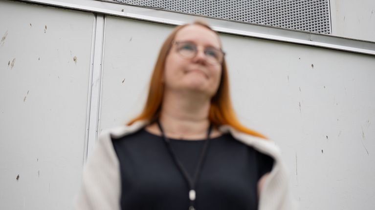 Nainen kirjastolla, jonka seinässä on linnun ulostetta.