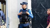 El Salvadorilainen poliisi valvoo kadulla luotiliivit päällään.