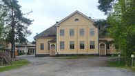 En gammal byskola i gulmålat trä.