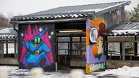 Kaksi graffitihahmoa Kouvolan aseman ulkoseinissä.