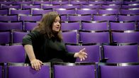 Toimittaja, teatteriohjaaja Susanna Kuparinen tyhjässä teatterikatsomossa.