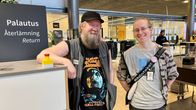 Two smiling men standing in a library. 