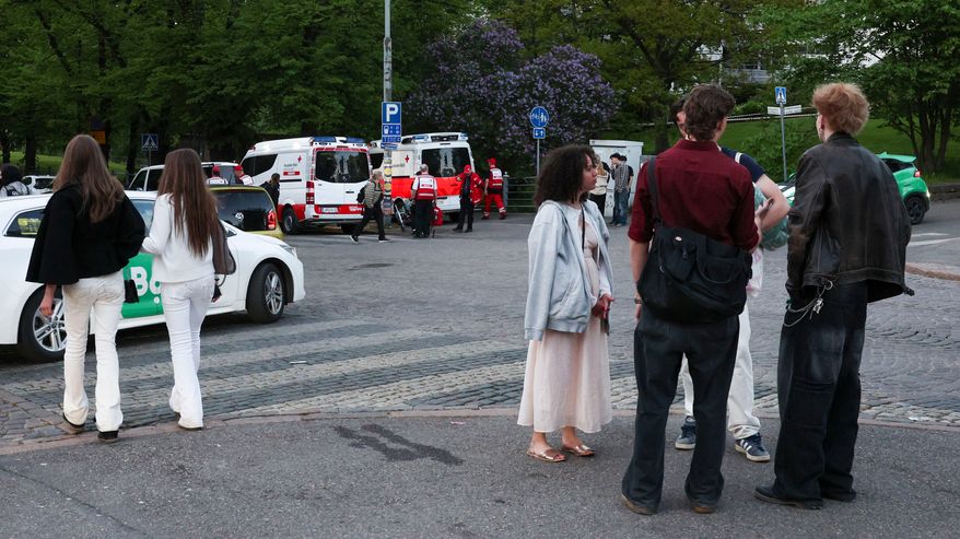 Nuoria seisoskelee jalkakäytävällä tien risteyksessä. Taustalla Suomen Punaisen Ristin autoja ja henkilökuntaa.
