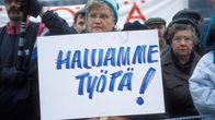 Työttömien mielenosoitus eduskuntatalon edessä Helsingissä marraskuussa 1993, nainen ja kyltti, jossa lukee "Haluamme työtä!".