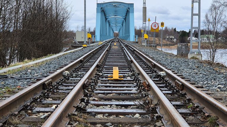 Torniosta Ruotsiin menevä junaraide. Taustalla rautatiesilta.