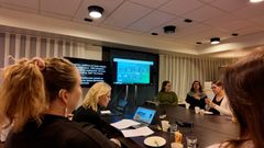 Yle-raatilaisia kokouksessa, jossa hyödynnetään tekstitysnäyttöä ja viittomakielen tulkkeja saavutettavuuden tukemiseksi.