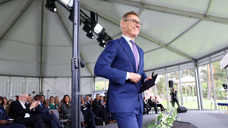 Alexander Stubb seisoo ulkoteltassa yleisön edessä.